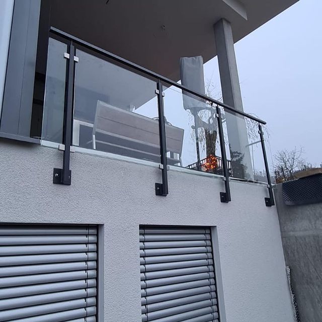Balkongeländer aus Stahl und Glas an einem modernen Wohnhaus