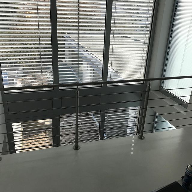 Innengeländer aus Stahl und Glas an einer Galerie im Obergeschoss