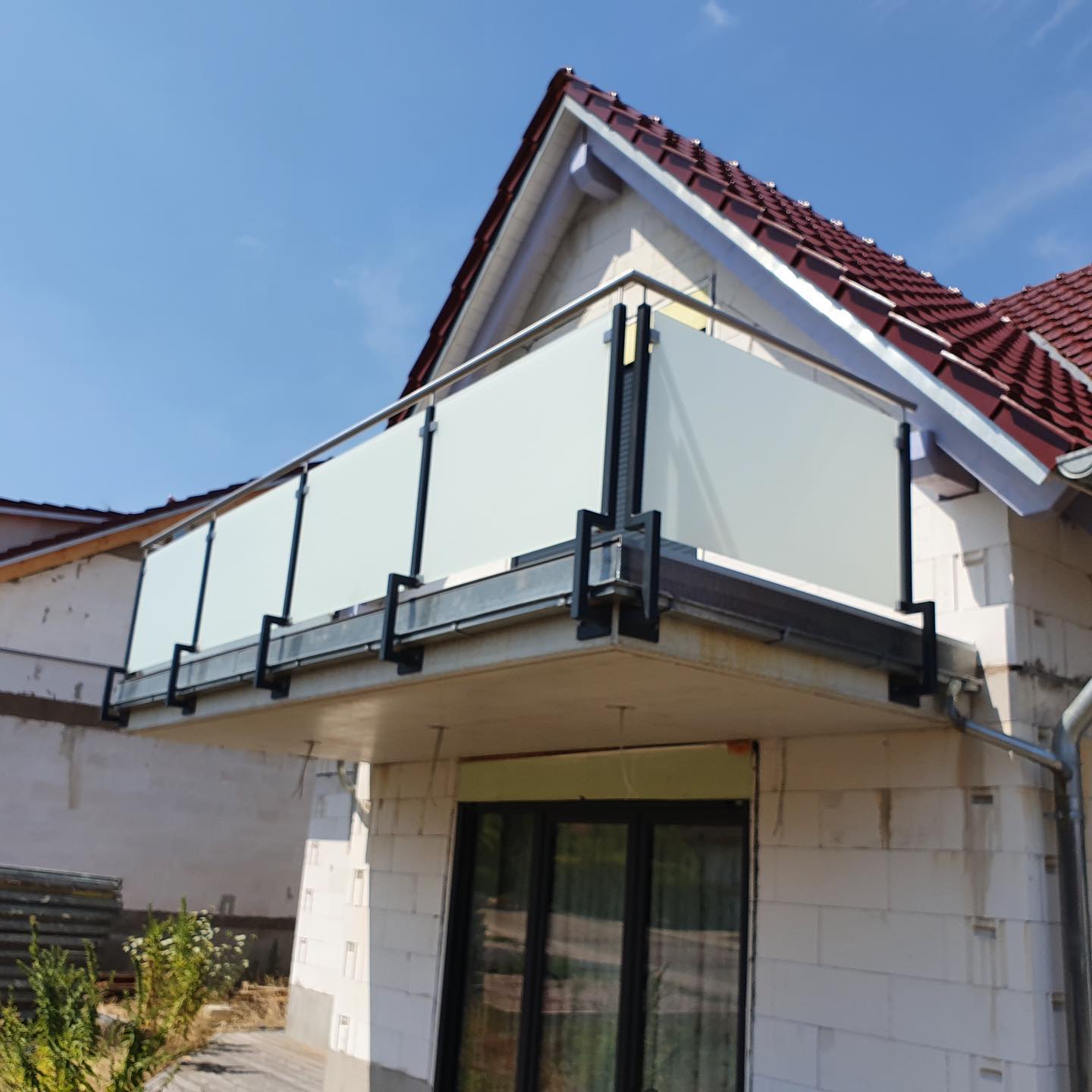 Anbaubalkon mit Milchglasfüllung und Edelstahl-Handlauf an Neubau