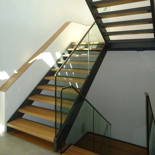 Holztreppe mit Stahlrahmen und Glasgeländer