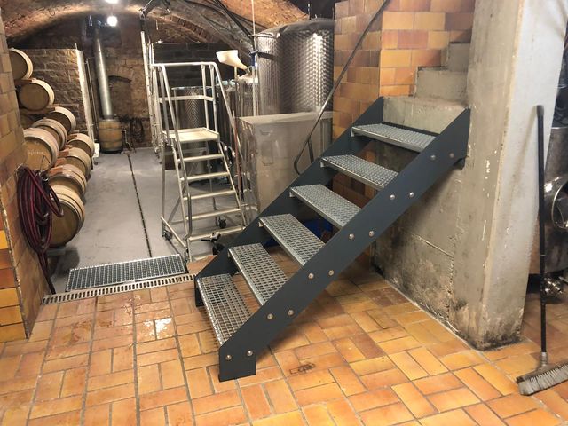Stahltreppe im Gewölbekeller mit Weinfässern